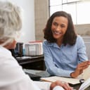 Female analyst smiling during a mentoring session with a senior woman