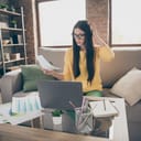 A confused woman scratching her head while looking at documents
