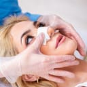 Woman getting her nose operated on by a doctor