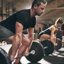 man and woman preparing to lift barbells in a gym