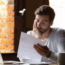 Confused frustrated young man reading letter in cafe, debt notification, bad financial report, money problem, money problem, upset student receiving bad news, unsuccessful exam or test results