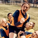 A girls sports team celebrating on the field