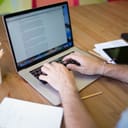 A person writing an essay on a laptop