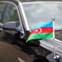 Flag of Azerbaijan at the diplomatic black car. Diplomat of Azerbaijan. Azerbaijan flag waving on ambassador's car. Tricolour, with a white crescent and an eight-pointed star in the center