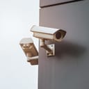 two outdoor security cameras that are part of an IP CCTV home security system for video surveillance and control