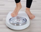 Person about to step onto a scale to weigh themselves