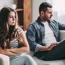Upset couple sitting next to each other on a couch