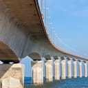 View of a bridge on water supported by concrete pillars