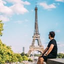 picture of a man during his summer vacation in Paris, with the Eiffel Tower in the background