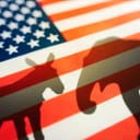 A silhouettes of a donkey and an elephant on a US flag
