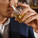 A drink for the man. Cropped closeup of a man drinking whiskey at the bar