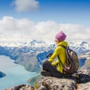 A woman sitting on a mountain on pot of Norwegian fjords