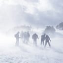 A group of skiers faces a fierce wind and blizzard conditions while skiing in the challenging weather of the Pyrenees in Andorra.