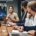 A young businesswoman guides a conversation among her team members in their contemporary workspace.