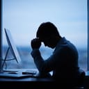 Disappointed man sitting in front of a computer at work