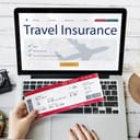 Woman holding an airline ticket while buying travel insurance on laptop