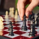 close-up of a chess player's hand moving the king piece on a chess board
