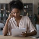 A confused young woman reading a paper document, concerned about the results of research.