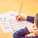 a child practicing cursive writing on paper