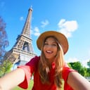 Selfie girl in Paris, France. Young tourist woman taking self portrait with Eiffel Tower in Paris.