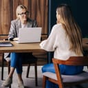 female HR professional conducting a job interview with a female candidate in a modern office