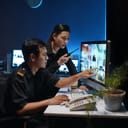 two security personnel monitoring surveillance cameras in the office