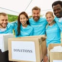 Group of volunteers smiling in front of a donation box
