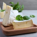 Delicious brie cheese with basil on light grey table