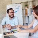 Two workers amicably chatting in the office