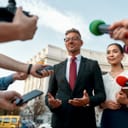 A politician answering questions from the press in front of a government building