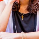 a woman wearing a cross rosary around her neck