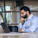 Man sitting pensively in front of laptop