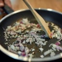 Onions being fried in a pan