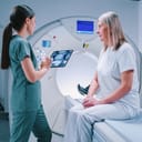 female doctor showing MRI scans on a tablet to a female patient in a tomography chamber