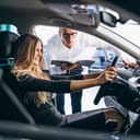 A woman trying out a car at a dealership