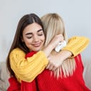 Two women supportively hugging each other