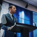 A man in a suit giving a speech