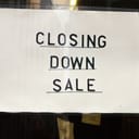 A closing down sale sign on a piece of paper stuck to a store window