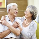 A senior couple embracing and looking into each other's eyes