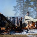 The remains of a cabin, with flames still consuming what's left of the structure.