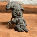 Native American clay figurine displayed on sand
