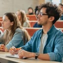 Multi-ethnic students in a classroom listening and writing notes during a lecture at college