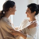 side view of two happy women catching up and cuddling after not seeing each other for a long time