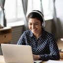happy young girl with headphones engaging in the conversation using her laptop