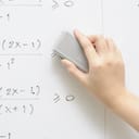 A tutor erasing equations from the whiteboard with a sponge