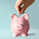 A person putting money into a piggy bank