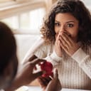 Woman with a stunned look on her face as she is offered an engagement ring