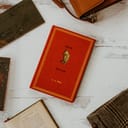 Winnie the Pooh book on a wooden table surrounded by different books