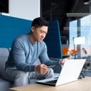Man holding a credit card confusingly looking at laptop