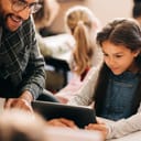 Teacher working with a girl on a tablet